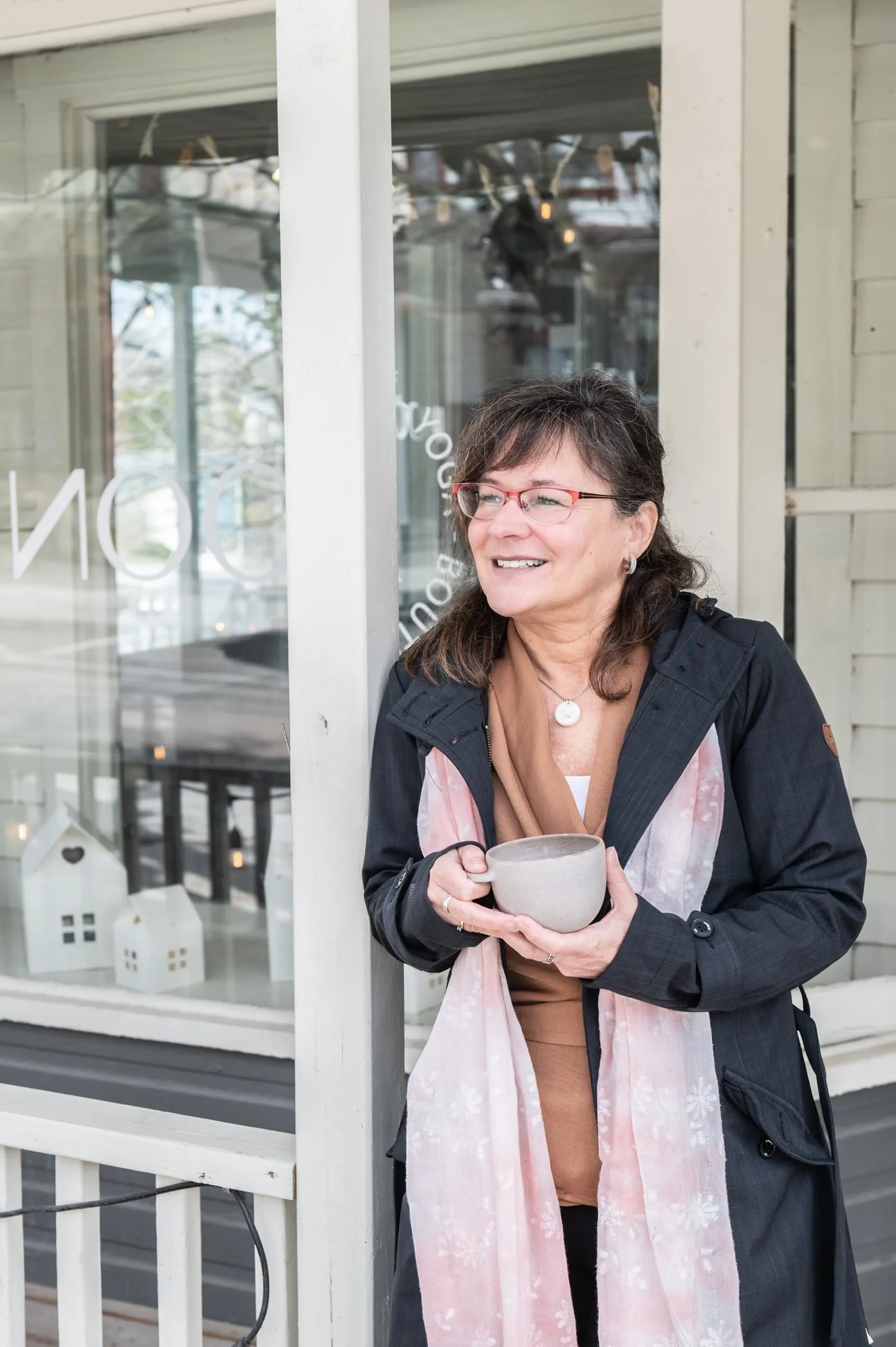 Joanne Vaillancourt, sourire aux lèvres, une tasse à la main