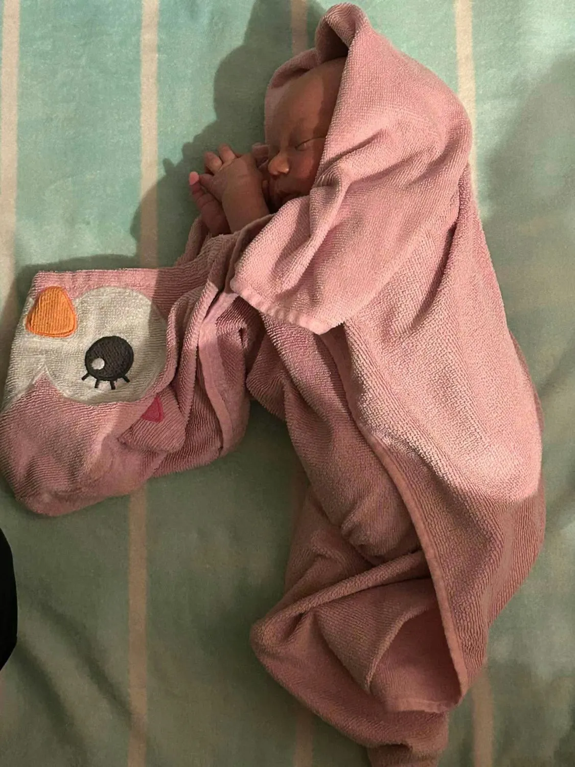 Bébé endormi dans une serviette rose après le bain
