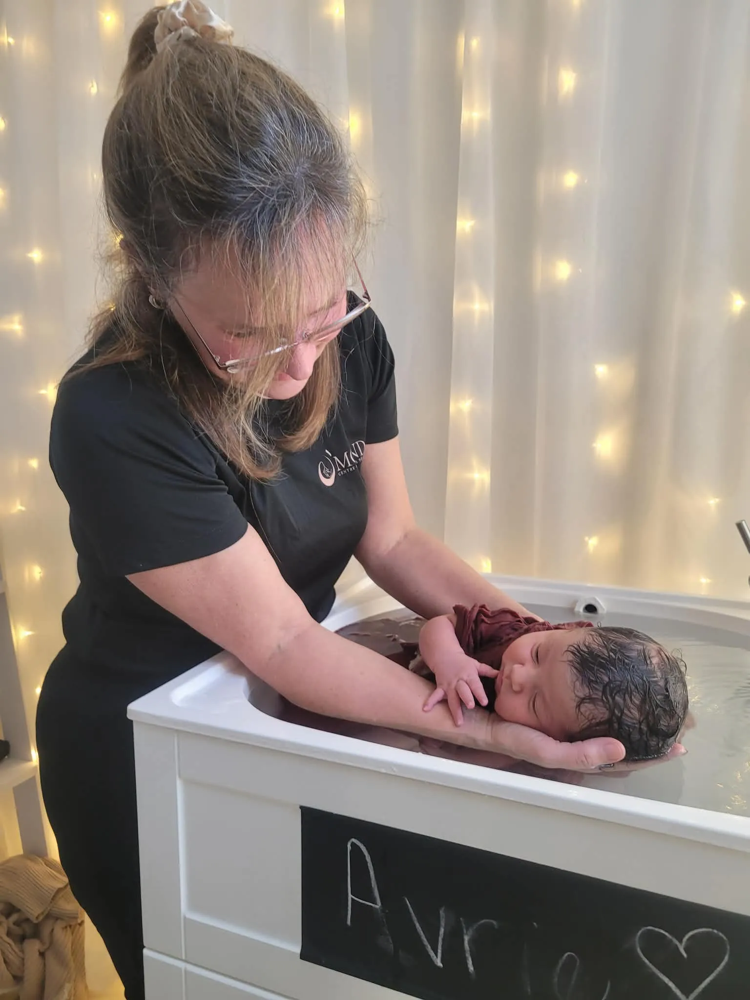 Joanne Vaillancourt soutient un nouveau-né emmailloté dans l'eau tiède du bain thalasso