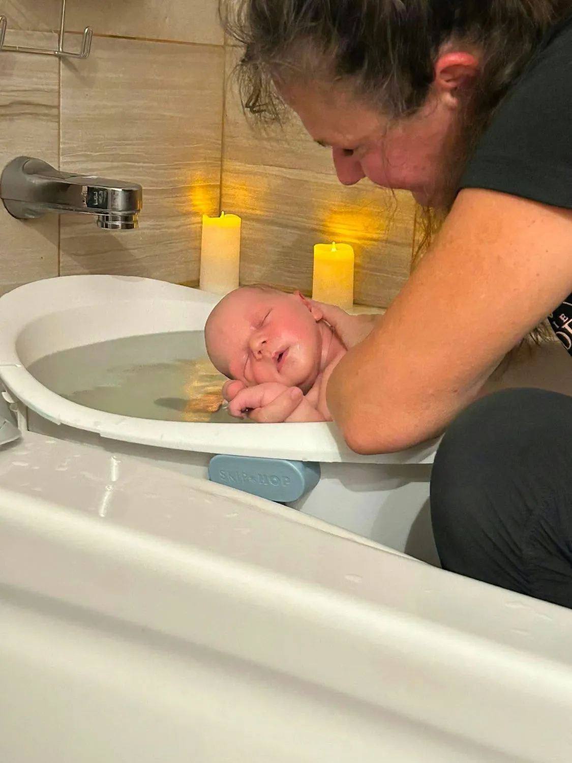Joanne soutient le nouveau-né qui flotte dans le bain